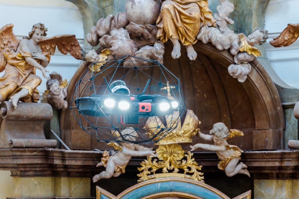 Dron v ochranné kleci snímkuje sochařskou výzdobu oltáře
